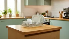 Küche mit Geschirr auf Abtropfgestell auf Holzinsel, moderner Stil, helle Einrichtung