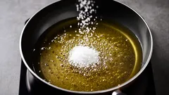 Salz wird in heißes Öl in einer Pfanne gegeben, Nahaufnahme beim Kochen.